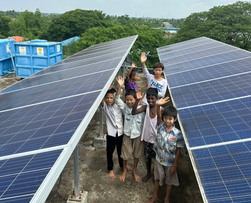 Glückliche Kinder bei den Solarpanelen