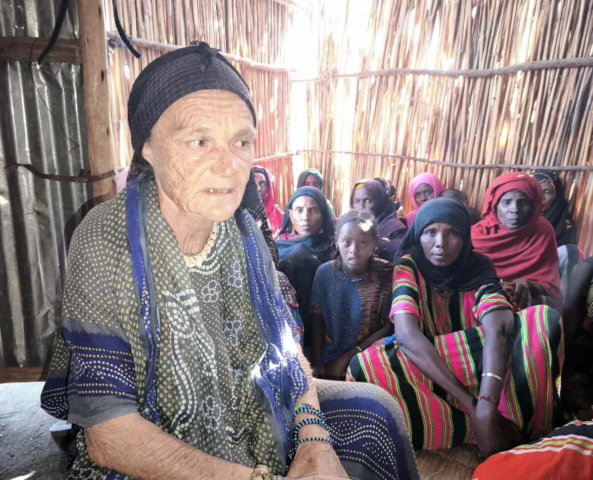 Valerie Browning sitzt in mit Afar Frauen in einer Strohhütte